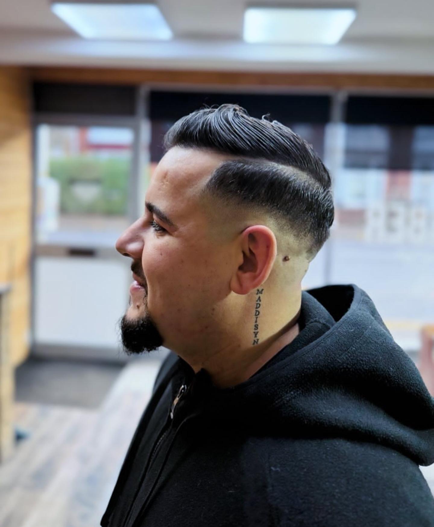 Slick pompadour with clean skin fade and defined beard