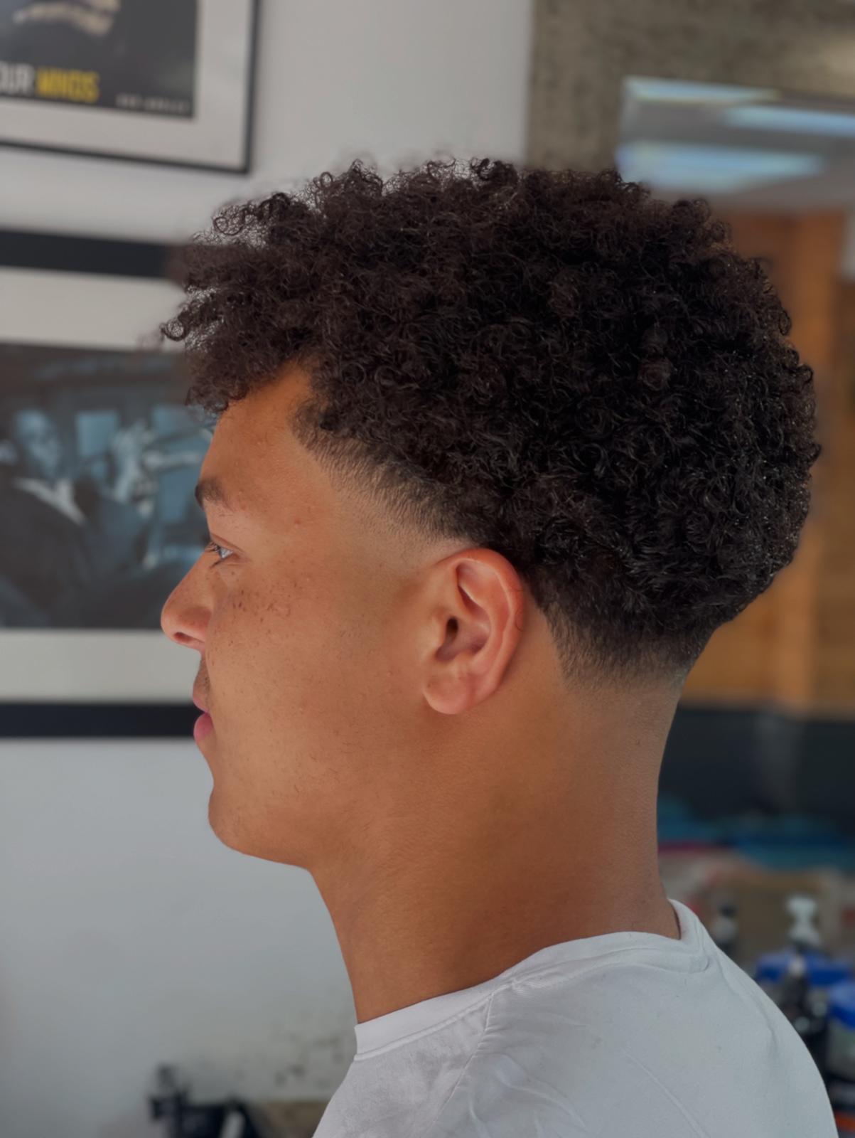 Defined natural curls with a mid taper fade